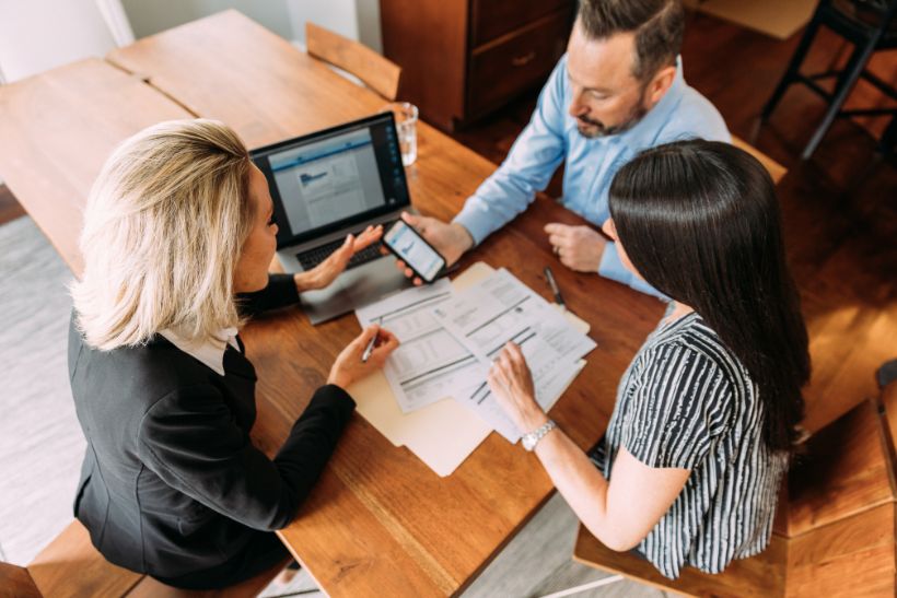 Tre persone sedute a un tavolo.
