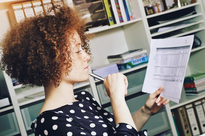 Ragazza che pensa con foglio in mano