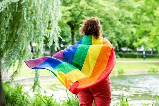 Persona di spalle con la bandiera simbolo LBTIQ+
